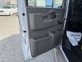 A 2020 Chevrolet Express van door with a gray interior panel featuring a door handle storage compartments and a window crank on the armrest