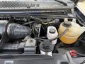 Engine compartment of a 2011 Ford Econoline showing the air intake hose coolant reservoir and various engine components