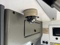 A round security camera mounted on the ceiling of a vehicle interior
