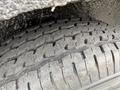 Close-up of a textured tire showing deep treads and wear patterns indicating usage and road contact