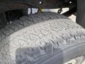 Close-up of a worn tire from a 2007 Ford F-350 SD showcasing deep treads and dirt accumulation on the surface
