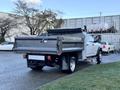 A 2021 RAM 5500 truck with a flatbed and dump feature parked at an angle showing the rear and side view of the vehicle