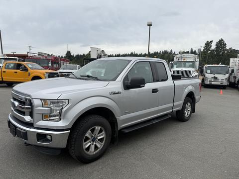 A 2015 Ford F-150 pickup truck in silver with a single cab and chrome accents parked on a lot