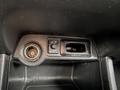 A close-up view of the control panel in a 2016 Mitsubishi Outlander featuring a power outlet and buttons for activating features