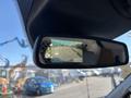 A 2016 Ford Transit 150 displaying a rearview camera feed on the rearview mirror screen