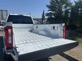 A 2023 Ford F-350 SD with an open truck bed showcasing a white interior and tailgate down