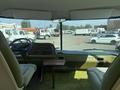 Interior view of a 1976 GMC Motorhome featuring a steering wheel and two front seats with green upholstery and a dashboard with various controls and gauges