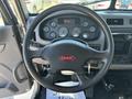 Steering wheel and dashboard of a 2020 Peterbilt 330 showing various gauges and a central warning display