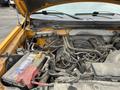 A 2014 Ford F-150 engine bay featuring various components including the engine block battery and intricate wiring