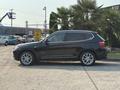 A black 2013 BMW X3 parked on a concrete surface featuring five-spoke alloy wheels and a sleek profile