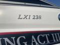 A white boat with a dark stripe featuring the text LXI 238 on the side