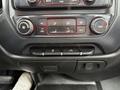 Dashboard controls of a 2015 GMC Sierra 1500 featuring climate control knobs and buttons for media settings and other functions