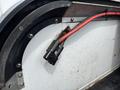 A close-up view of a Chevrolet Colorado's interior showing a red wire connected to a black electrical connector mounted on a metal surface