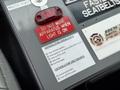 A 2007 Ford F-550 dashboard with labels for generator operation and shutdown instructions alongside a red warning light and a master power switch