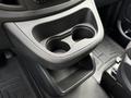 A black cup holder with two compartments and a lower storage space inside the console of a 2020 Mercedes-Benz Metris