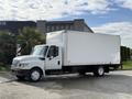 A white 2014 International TerraStar truck with a large box cargo area and single rear wheels parked on a pavement