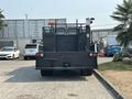 A black 2006 Sterling Acterra truck with a high rear compartment and safety lights on top parked in a lot
