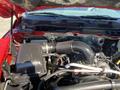Engine compartment of a 2015 RAM 2500 featuring a large air intake and various hoses and components prominently displayed