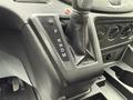 The gear shift of a 2017 Ford Transit T150 XLT with a black leather cover showing P R N D M positions