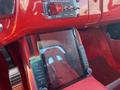 A tablet is mounted on the dashboard of a red 1962 Ford 2WHDR with controls on one side and a racing seat visible in the background