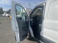 A white 2017 Ford Transit van with its driver's side door open displaying the interior and dashboard