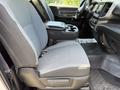 Interior view of a 2020 Ram 2500 showing the front passenger seat with gray fabric upholstery and a center console featuring cup holders and keys on the seat