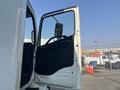 A 2012 Hino 338 truck with an open door showing the driver's seat and steering wheel visible inside the cab