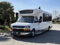 A 2017 Chevrolet Express shuttle bus in white with tinted windows and a large front windshield