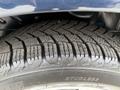 Close-up of the tread pattern on a winter tire mounted on a 2013 Dodge Journey showing deep grooves and a studless design for better traction on snow and ice