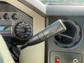 Close-up of a 2008 Ford F-450 SD gear shift lever with a tow haul button next to a dashboard displaying speedometer and various controls