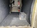 Interior of a 2015 Ford F-550 with gray carpeting and a metal storage box on the floor