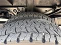 Close-up of a large, rugged tire with deep treads mounted on a Ford F-450 Super Duty vehicle
