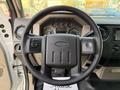 Steering wheel of a 2010 Ford F-550 with control buttons and dashboard gauges visible in the background