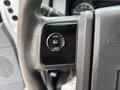 Close-up of a Ford F-250 SD steering wheel control panel featuring buttons for setup info and reset