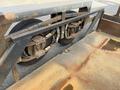 Close-up of the rear wheel assembly of a 2013 JLG Industries 1014 featuring dual wheels with metal brackets and a textured metal surface