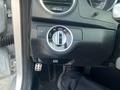 A close-up view of the control panel in a 2013 Mercedes-Benz C-Class showing the headlight switch and parking brake button