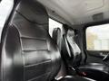 Two black leather seats inside a 2016 Peterbilt 348 truck cabin with ergonomic design and headrests