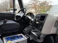 Interior dashboard of a 2014 International 7500 featuring controls gauges and a cup holder with a view of the steering wheel and seat