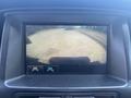 Display screen showing the rearview camera view of a 2017 Chevrolet Colorado driving on a dirt road