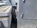 A 2010 aluminum 16 foot boat showing its side and storage compartments with visible wear and debris inside