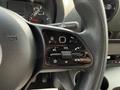 Close-up of the steering wheel controls of a 2023 Mercedes-Benz Sprinter showing buttons for volume phone and various functions