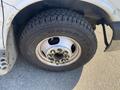 Close-up of a Goodyear tire mounted on a silver steel wheel with visible lug nuts on a 2011 Chevrolet Express van