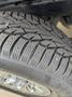 Close-up of a tire with detailed tread patterns and visible metal studs designed for traction on ice and snow