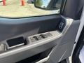 The interior door panel of a 2021 Ford F-150 featuring control buttons for windows and mirrors