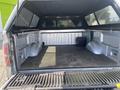 The image shows the bed of a 2014 Ford F-150 with a lined surface and a toolbox in the corner