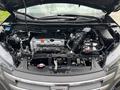 Engine compartment of a 2014 Honda CR-V showing the engine assembly battery and various mechanical components