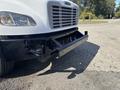 A 2014 Freightliner M2 106 truck with a black front bumper and grill visible in the foreground