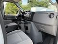 Interior of a 2013 Ford Econoline displaying the driver's seat dashboard and center console with cup holders and control knobs
