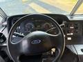 Steering wheel and dashboard of a 2012 Ford Econoline featuring instrument gauges and control switches