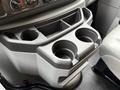 Cup holder compartment of a 2019 Ford Econoline featuring two recessed cup holders and a storage space above